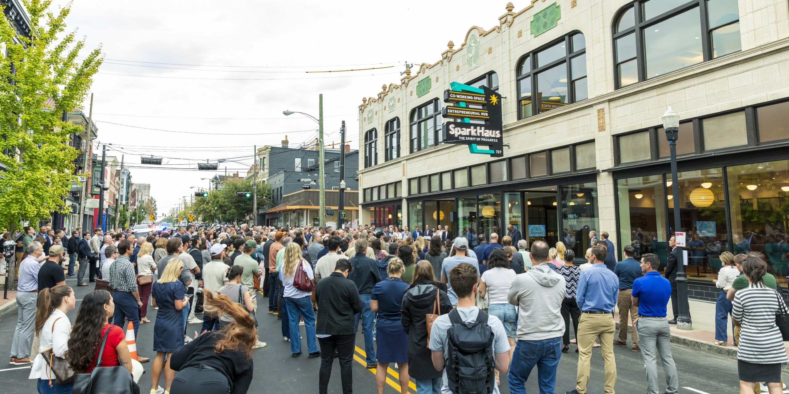 Exterior of SparkHaus at grand opening with people standing on Madison Avenue