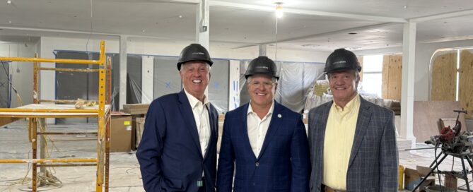 Judges/Executive Gary Moore, Kris Knochelmann, and Steve Pendery smile for a photo during a tour of SparkHaus