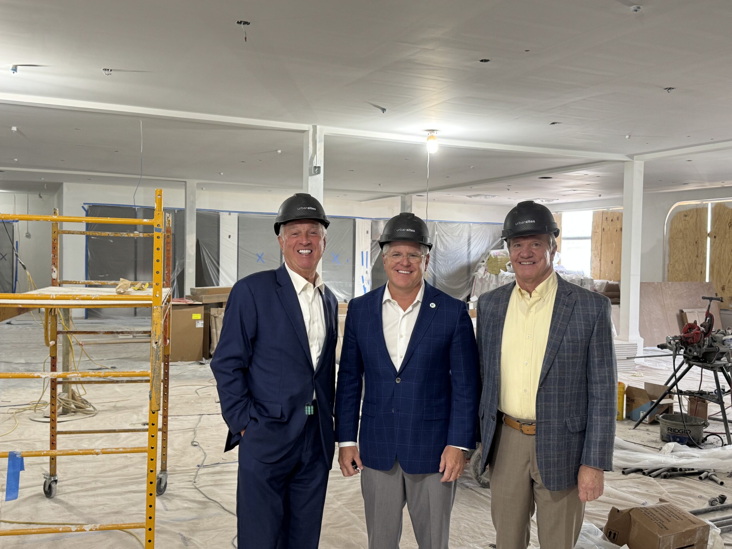 Judges/Executive Gary Moore, Kris Knochelmann, and Steve Pendery smile for a photo during a tour of SparkHaus