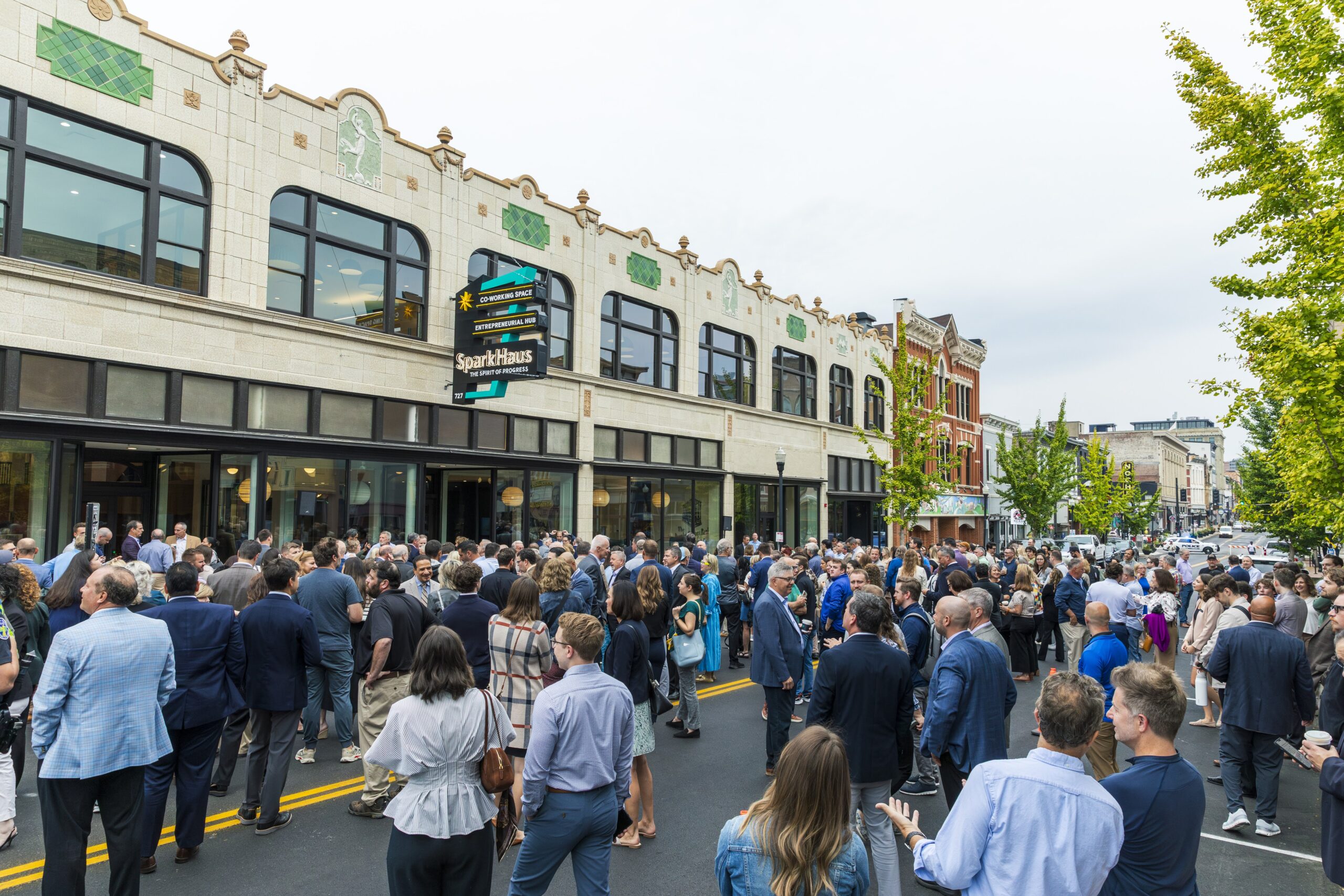 People standing on Madison Avenue in front of SparkHaus at grand opening